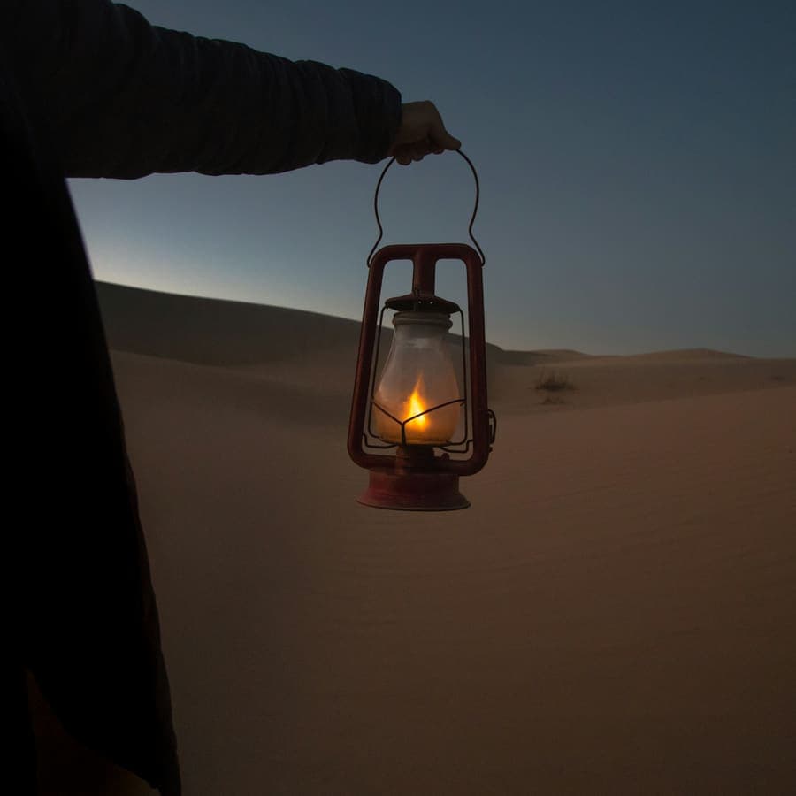 A lantern held up in the desert dark