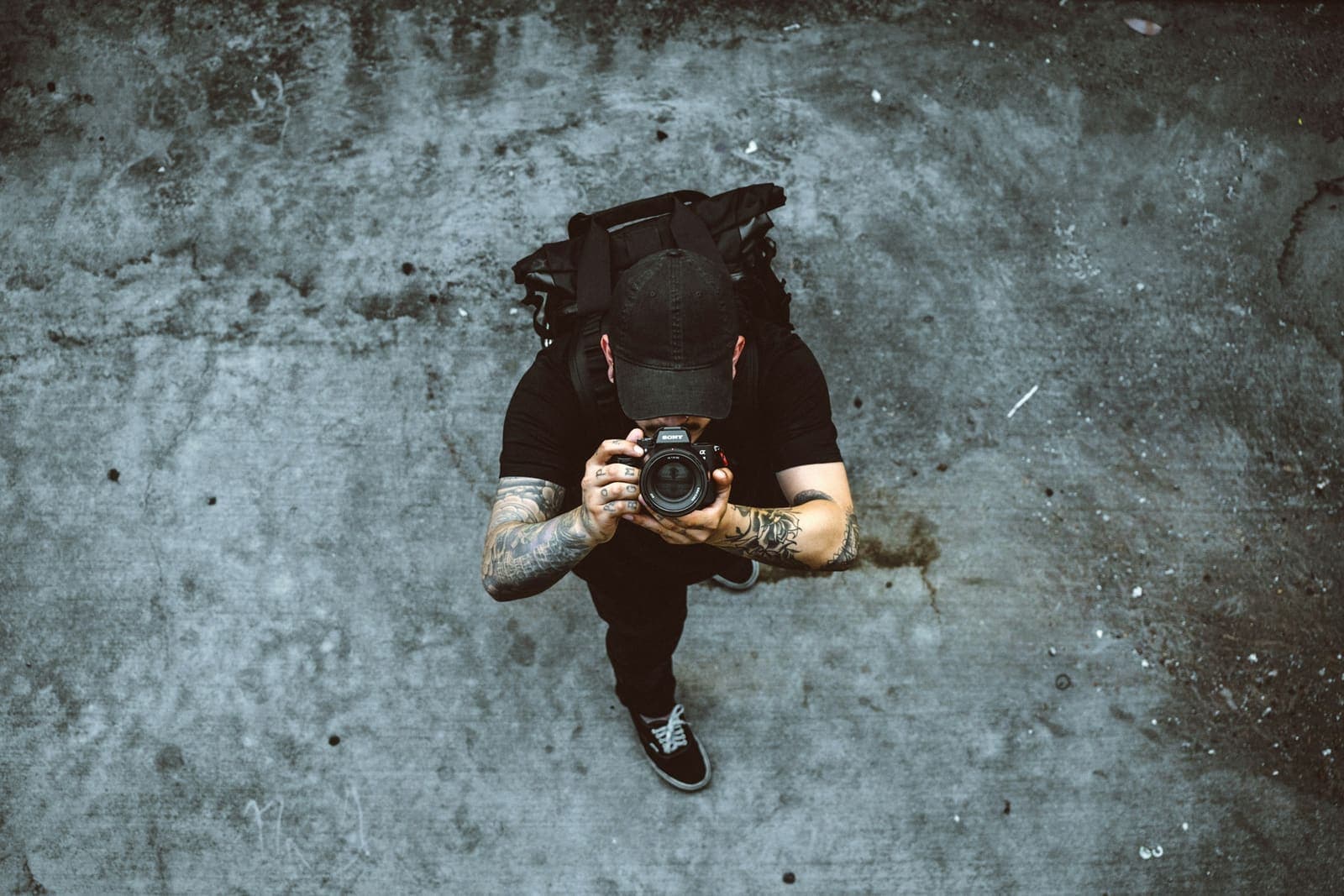 A photographer at work on grey concrete