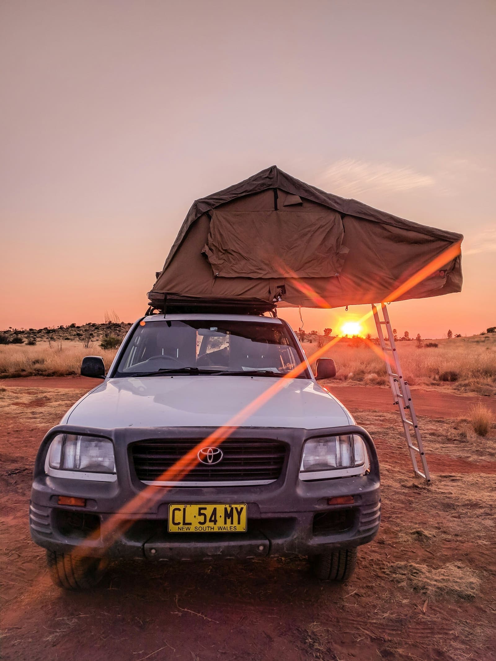 A rooftop tent lit by the last of the sun