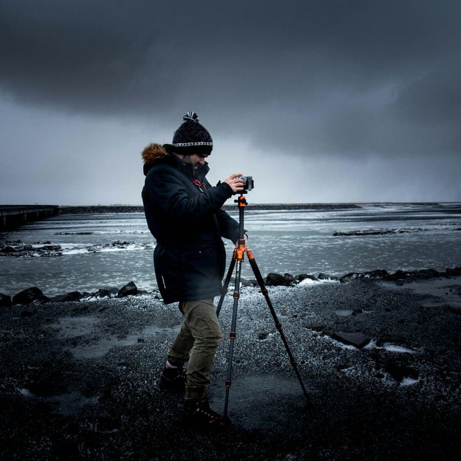 A photographer with a tripod at the sea