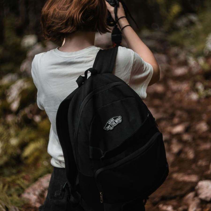 A woman holding a black backpack