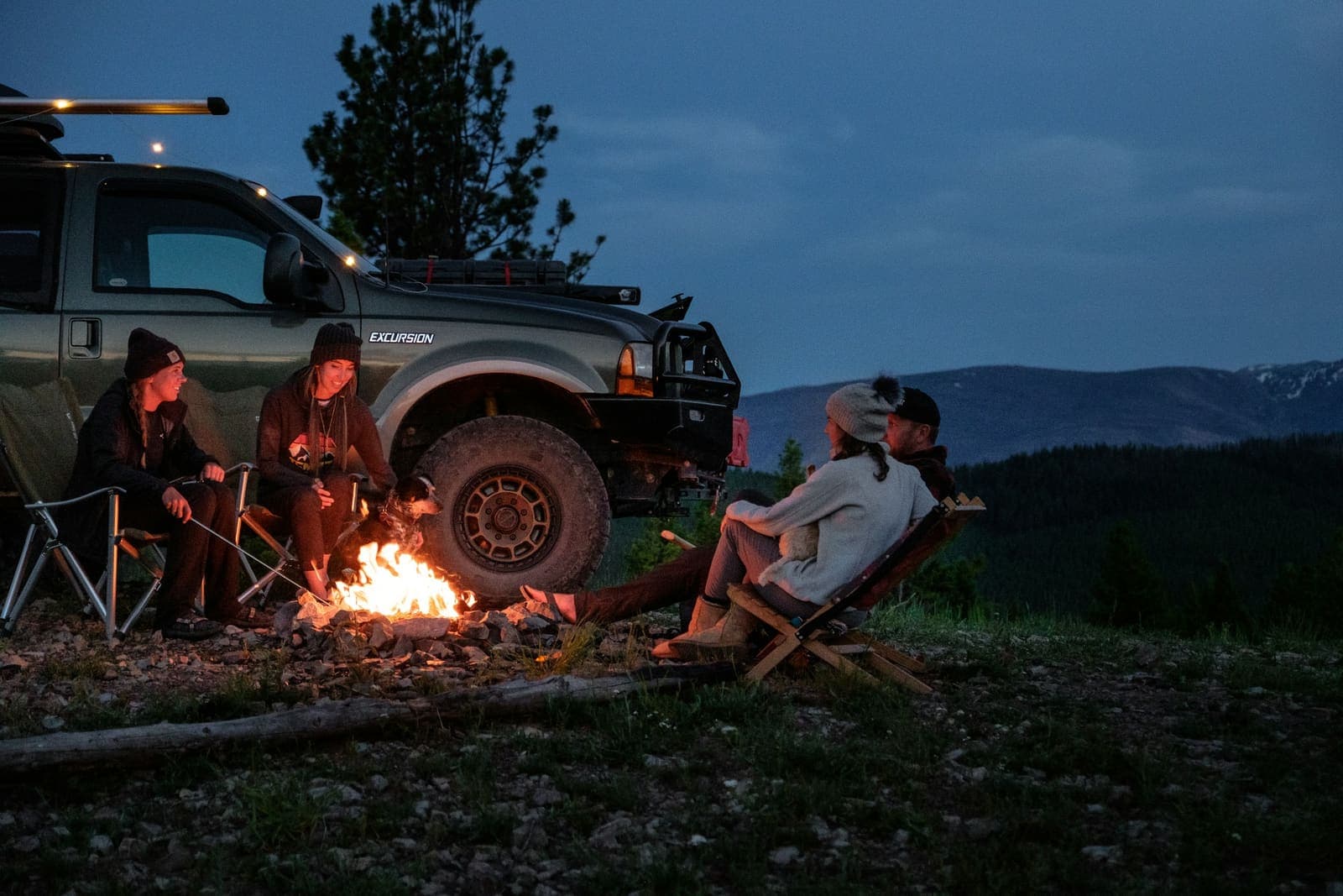 A campfire beside the truck at dusk