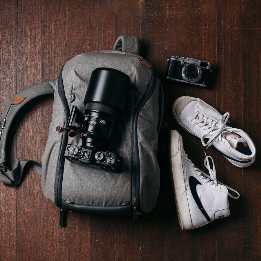 A camera and a pair of shoes on a wooden floor