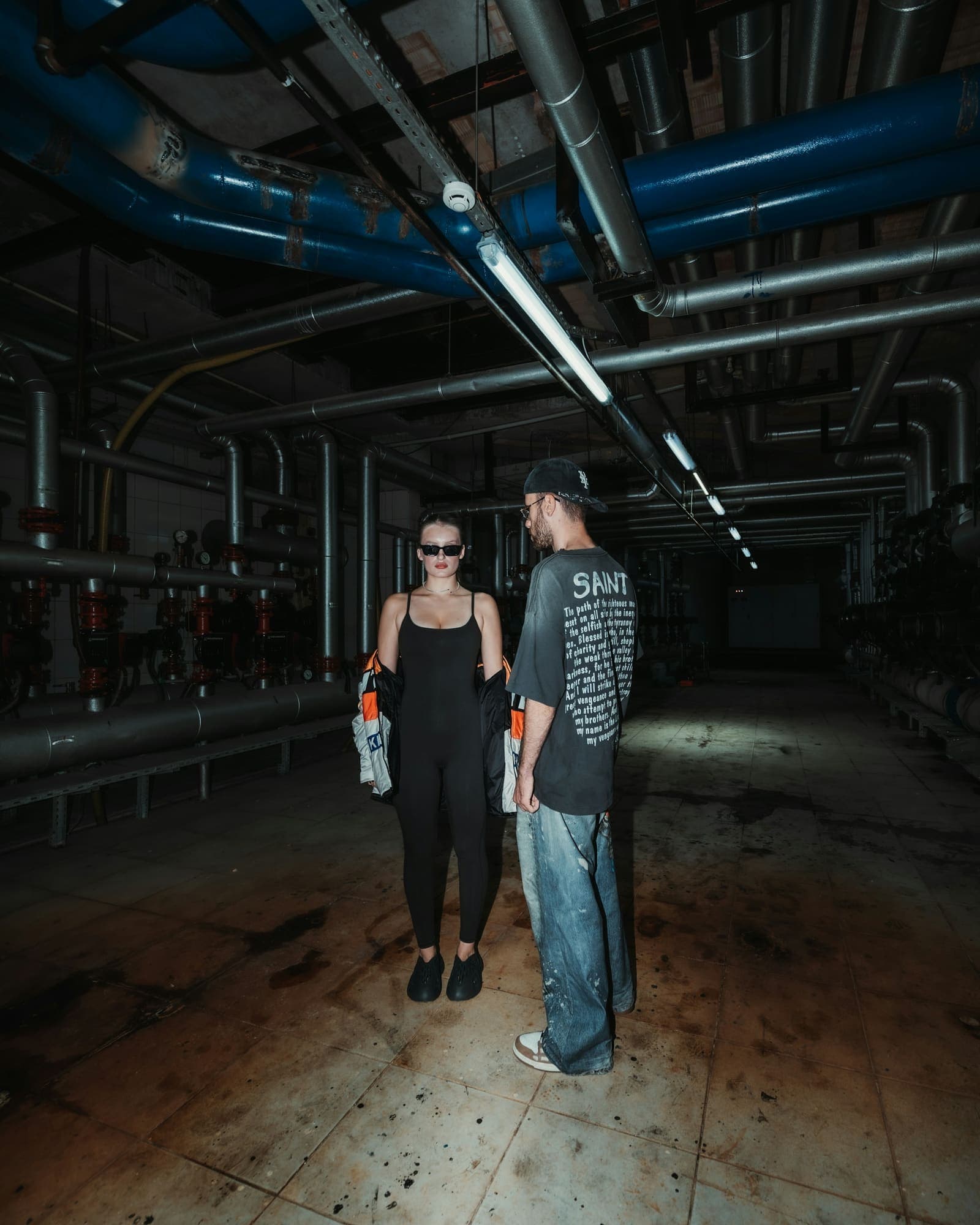 Two people in a dark room lit from the side