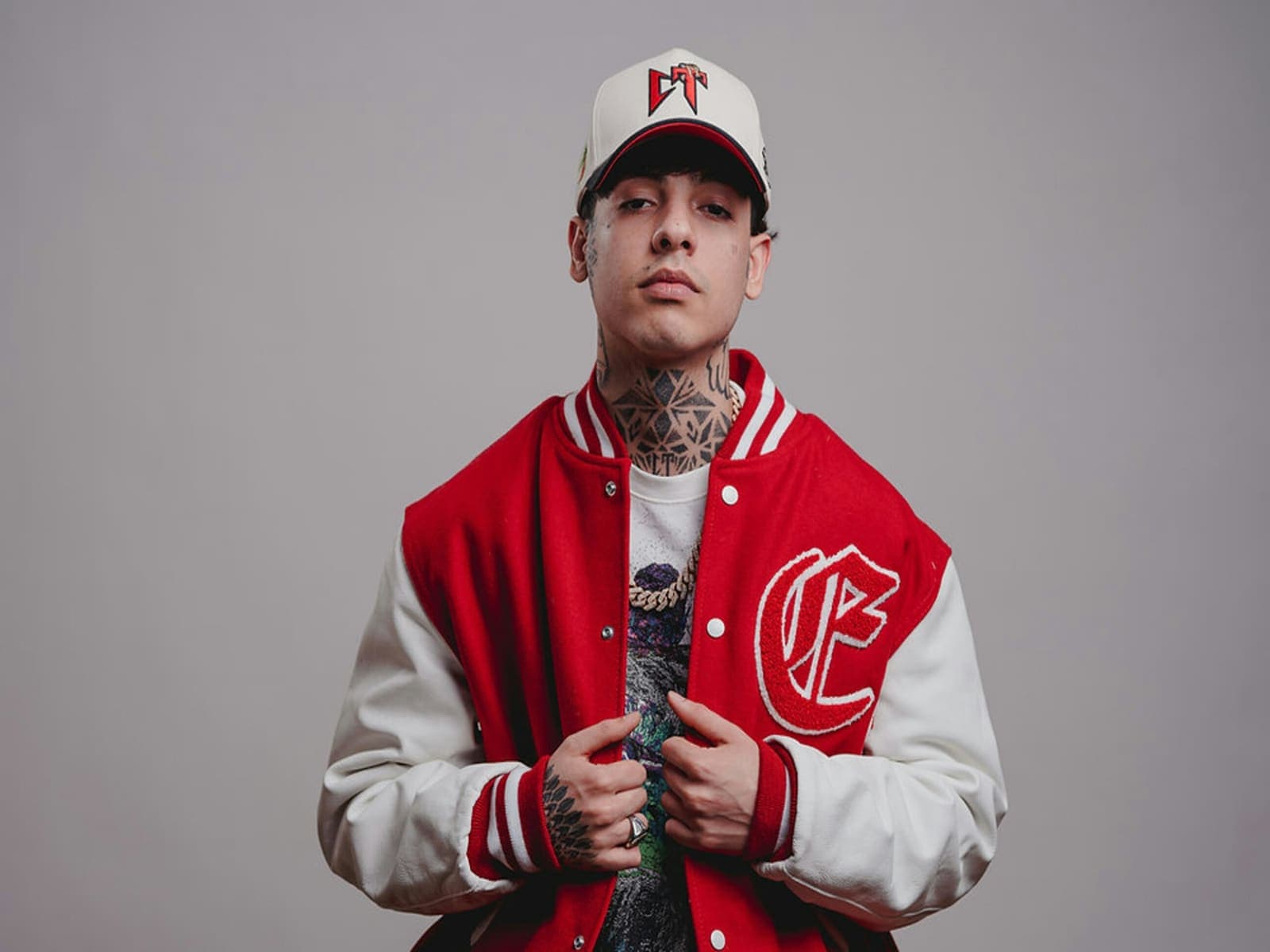 A young man in a cap and a varsity jacket