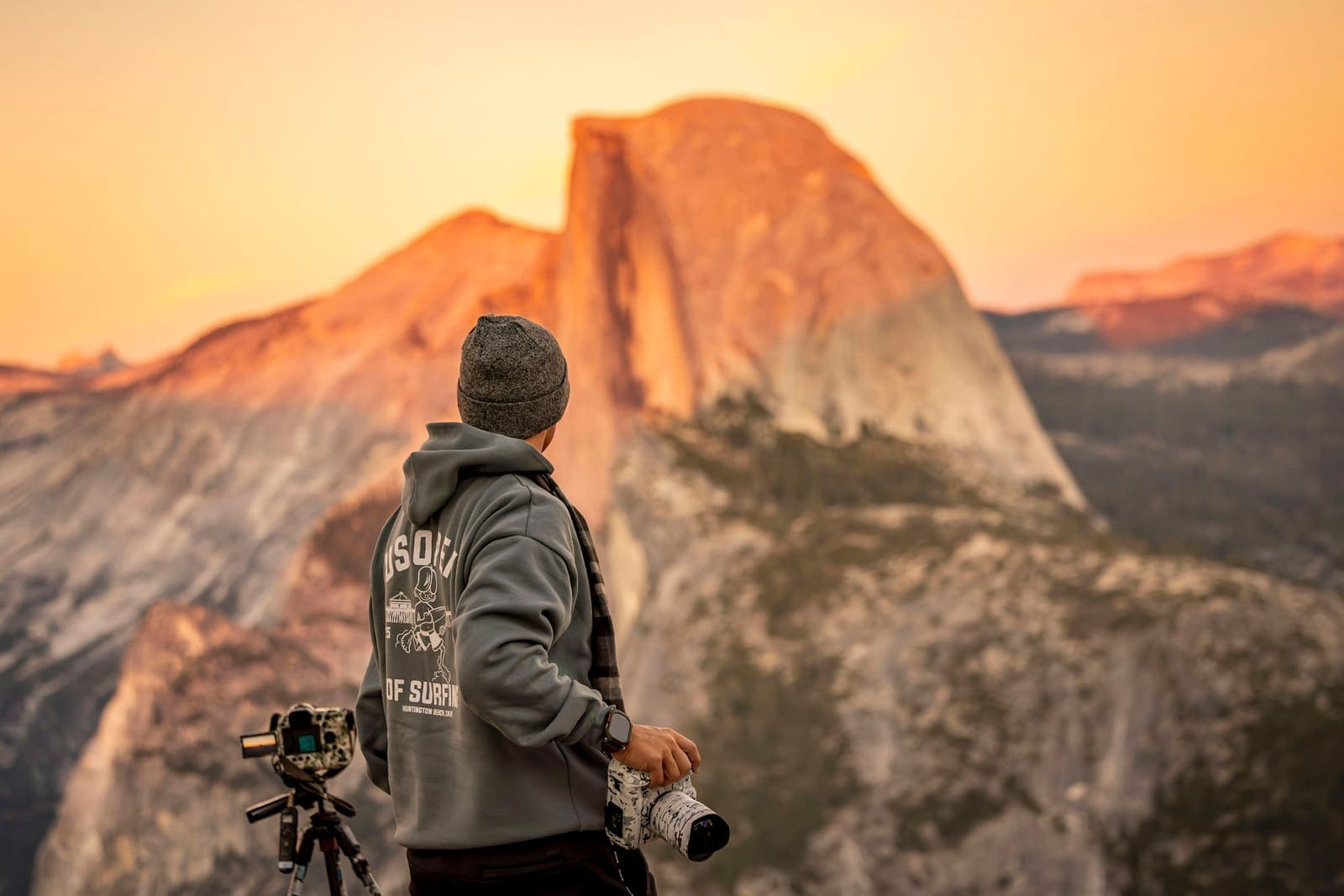 A photographer watches the sun set over the valley