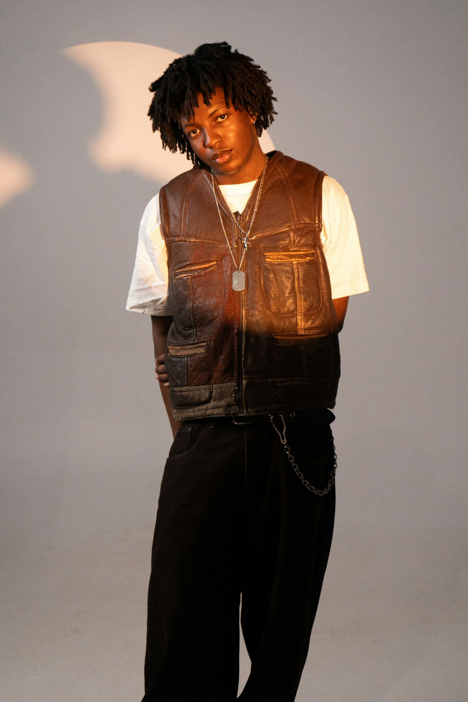 A young man in a vest and chain, close