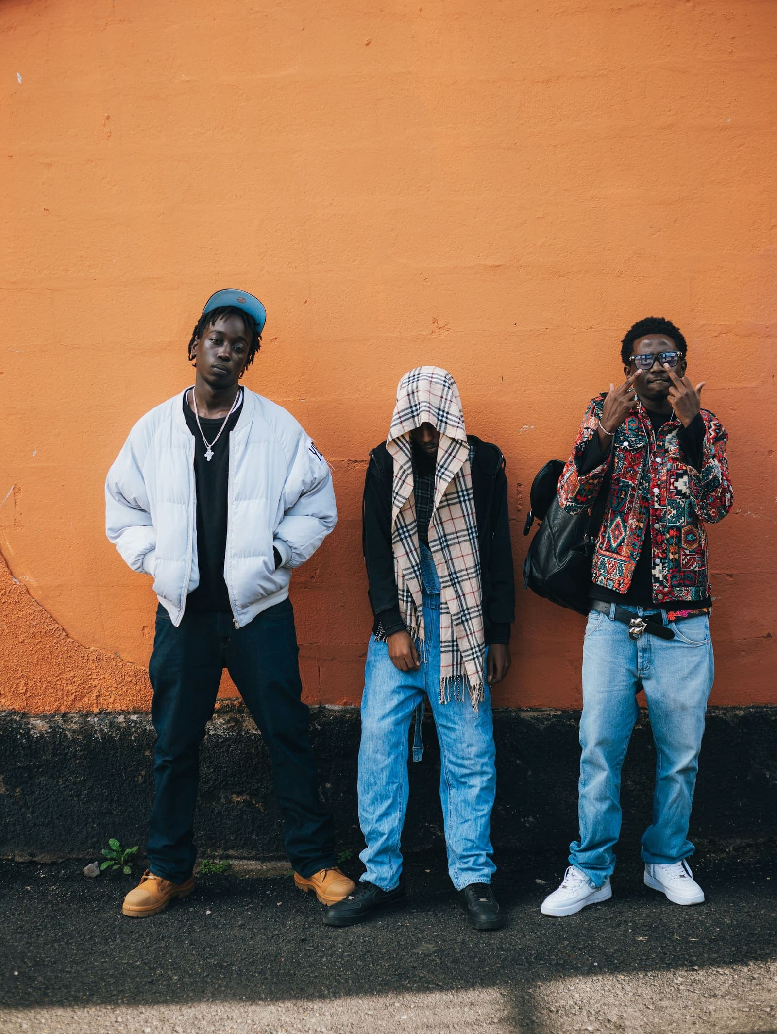 Three friends against an orange wall