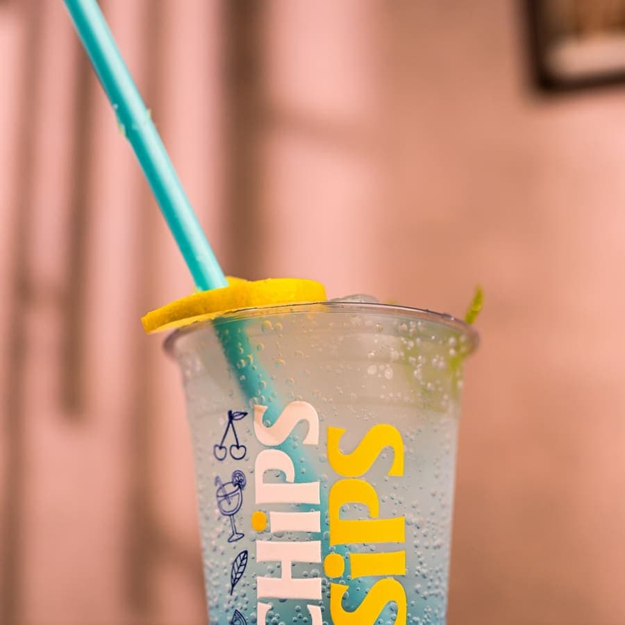 A drink with a blue straw and a lemon slice